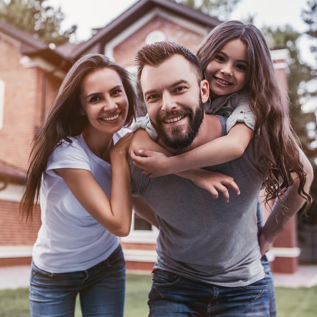 Happy family in front of home